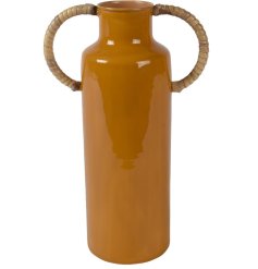 A tall glazed vase with two bamboo wrapped handles.