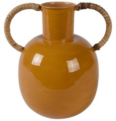 A boho round vase with a simple glaze. It details two bamboo handles,