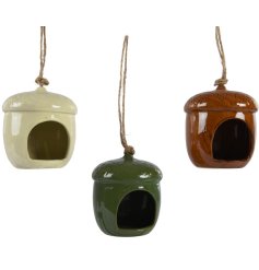 An assortment of 3 acorn shaped bird feeders. Each has beautiful carved detailing and a rich earthy glaze