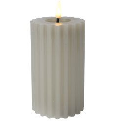 A small contemporary LED candle with a carved design. 