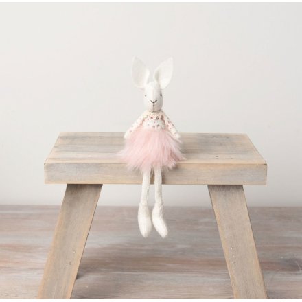 A sweet sitting rabbit with dangly legs and a faux fur pink tutu skirt.