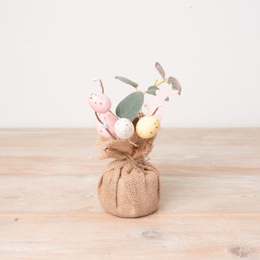 A pretty artificial Easter tree featuring an abundance of speckled eggs, a wooden bunny and hessian wrap base.  