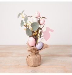 A charming and unique artificial Easter egg tree featuring speckled pastel eggs and wooden bunnies.