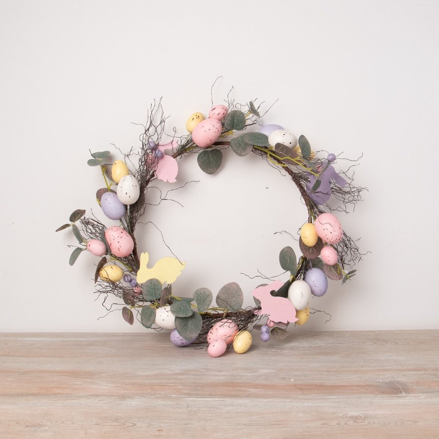 A beautifully detailed artificial twig wreath. A rustic decoration with pretty pastel coloured eggs and wooden rabbits.