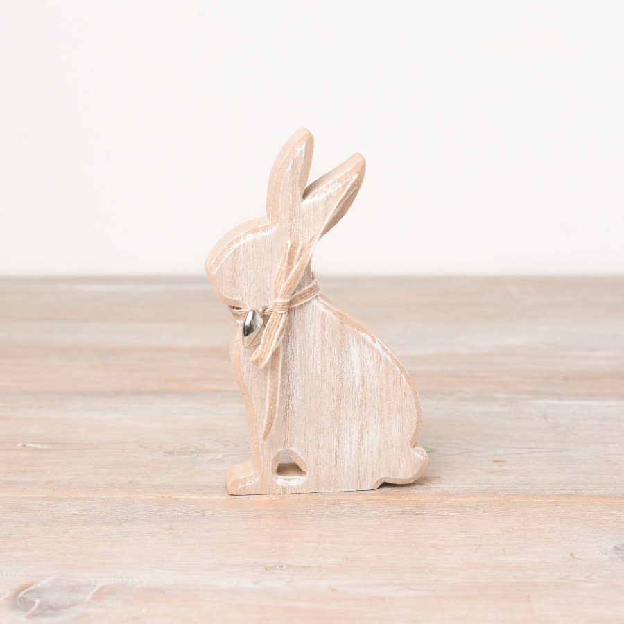 A rustic wooden bunny ornament with a washed natural finish. Complete with a fabric bow and silver heart charm.