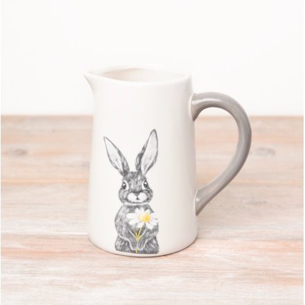 A white decorative jug adorned with a charming hare design holding a single flower. 