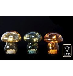 A glass mushroom light filled with warm white LED lights
