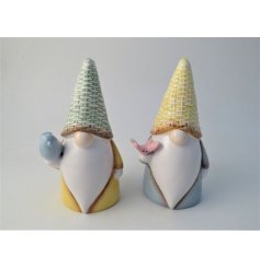 An assortment of two decorative gonks holding a bird/ butterfly finished with a simple glaze.