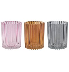 An assortment of 3 colourful candle holders in a vertical ribbed pattern. 