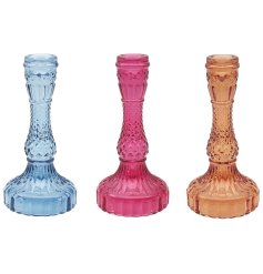 An assortment of 3 jewel style candle holders with a wide base and tall flute.