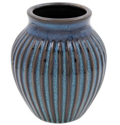 A wide ribbed vase in Blue colour tones with a reactive glazed finish. 