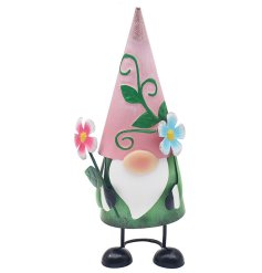A cute green gnome decoration wearing a pink and leaf style hat, holding a single pink flower.