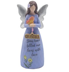 A statue featuring an angel figurine with a butterfly resting on her wrist, with a grandma motif hung from her hands