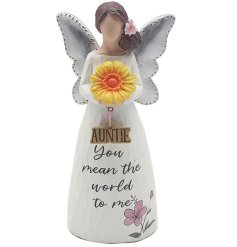 A statue figure of a woman holding a large flower wearing wings with scripted text on the body.
