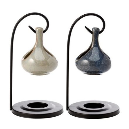 A teardrop style oil burner on a black stylish stand. 