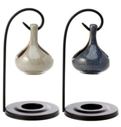 A teardrop style oil burner on a black stylish stand. 