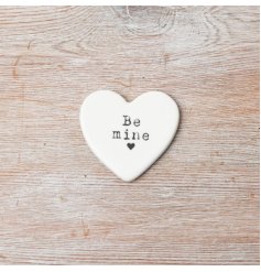 A charming small porcelain heart keepsake with the inscription 'Be Mine' at its center.