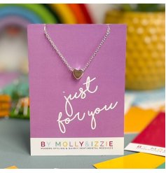 Backed onto an a7 card with scripted text, a silver plated heart necklace with a mini heart decal.