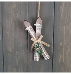 A hanging Christmas decoration in a ski design hung by jute twine. 