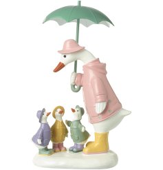A sweet duck family ornament showcasing a green umbrella covering the mother and her 3 baby ducklings. 