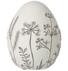 A white decorative egg ornament with intricate black floral detailing.  