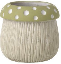 An earth coloured mushroom shaped pot with hand finished details and a polka dot design.