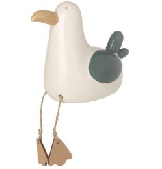A stylish sitting seagull decoration made from porcelain with jute hanging legs and wooden feet. 