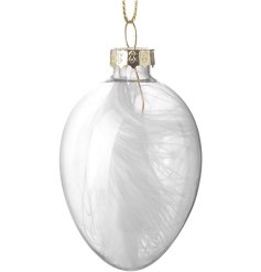 A glass egg decoration featuring a single white feather inside. 