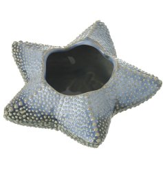 A starfish t light holder in deep blue with embossed markings.