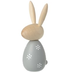 A natural wood bunny with pointed ears and a grey outfit. 