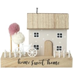 Add whimsical charm to the home with this dainty house decoration on a wooden stand. 