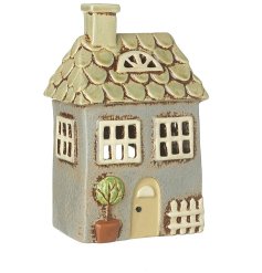 A small shabby chic t-light holder cottage with a rustic blue hue and country style details.
