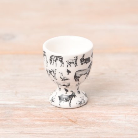 A farmyard style egg cup in white with black illustrations. 