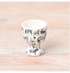 A white egg cup with black illustrations of farmyard animals