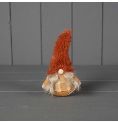 This cute gonk decoration features two pigtails hanging down from its orange fur hat and a tartan outfit. 