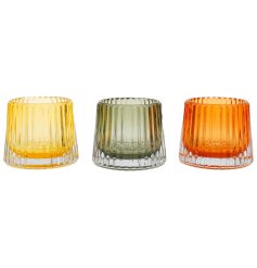 An assortment of 3 embossed tea light holders in green, yellow and orange colour tones. 
