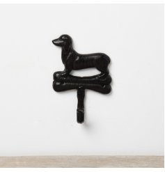 A simplistic wall hook made from cast iron featuring a Dachshund dog stood on top of a bone. 