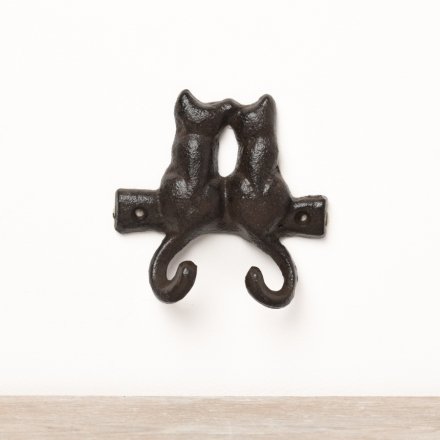 A simplistic cast iron wall hook featuring a pair of cats with their tails as the hooks. 