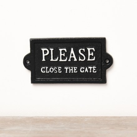 A jet black cast iron sign with white ' please close the gate' text.
