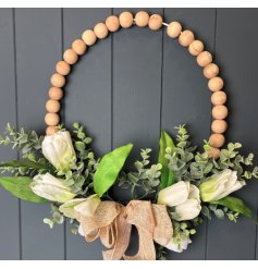 A gorgeous wreath adorned with white flowers, eucalyptus, and a jute bow