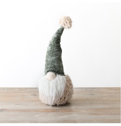 A charming seated gonk with a fluffy cream body and adorned with a plush forest green hat.