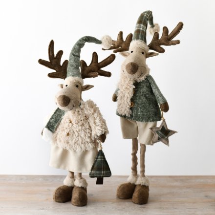 An assortment of two fabric moose with adjustable legs, embellished in a blend of green, tartan, and cream outfits.