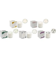 An assortment of five candles, each containing distinct crystals infused into the wax to enhance wellbeing