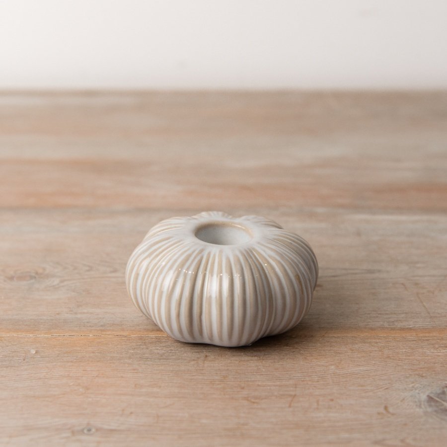 A delightful pumpkin-shaped dinner candle holder featuring a stylish natural glaz