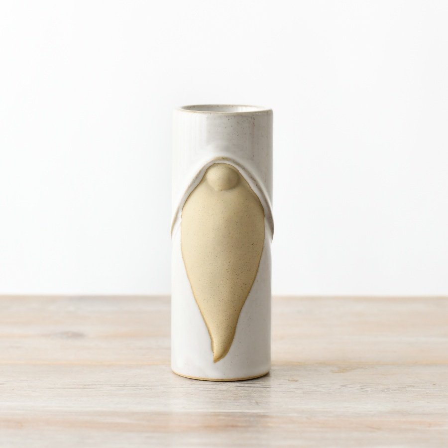 A tall ceramic tea light holder with a reactive glaze, showcasing charming gonk details, including a raw beard and nose