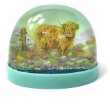 A colourful blue snow globe featuring an image of a highland cow, part of the the Jan Pashley range.