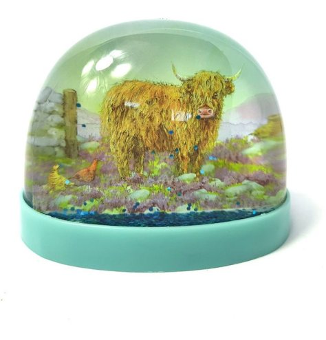 A country style festive snow globe showing an image of a Highland cow in a field. 