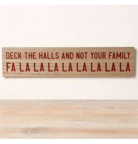 A funny wooden sign featuring the phrase "Deck the Halls And Not Your Family Falalalalala" in a dark red glitter font.