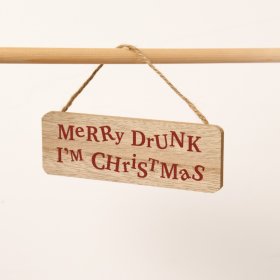 A playful wooden sign with the phrase "Merry Drunk, I'm Christmas" presented in a dark red, distorted font.