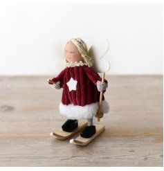 An adorable skiing angel wearing a red cord dress, with fluffy details.